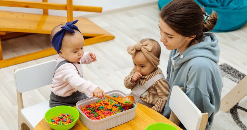 picture of young toddlers playing with a sensory bin