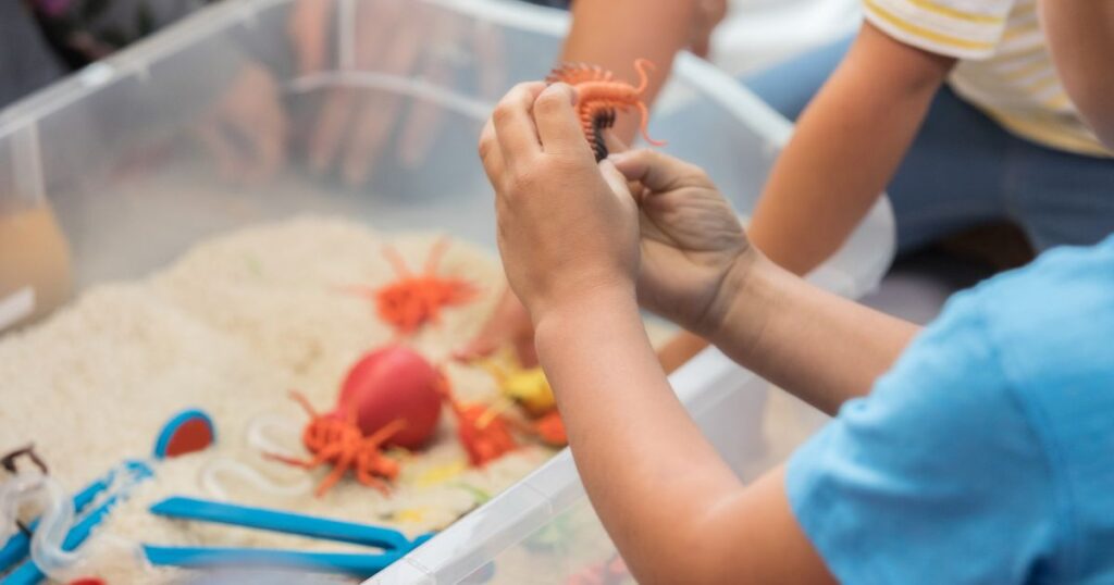 picture of toddlers playing with a sensory bin